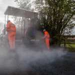 tarmac being machine laid to repair broken road surface