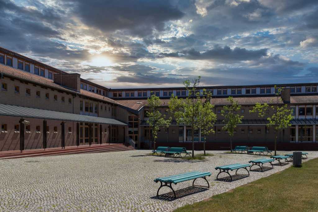 View across courtyard with benches to large school building