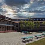 View across courtyard with benches to large school building