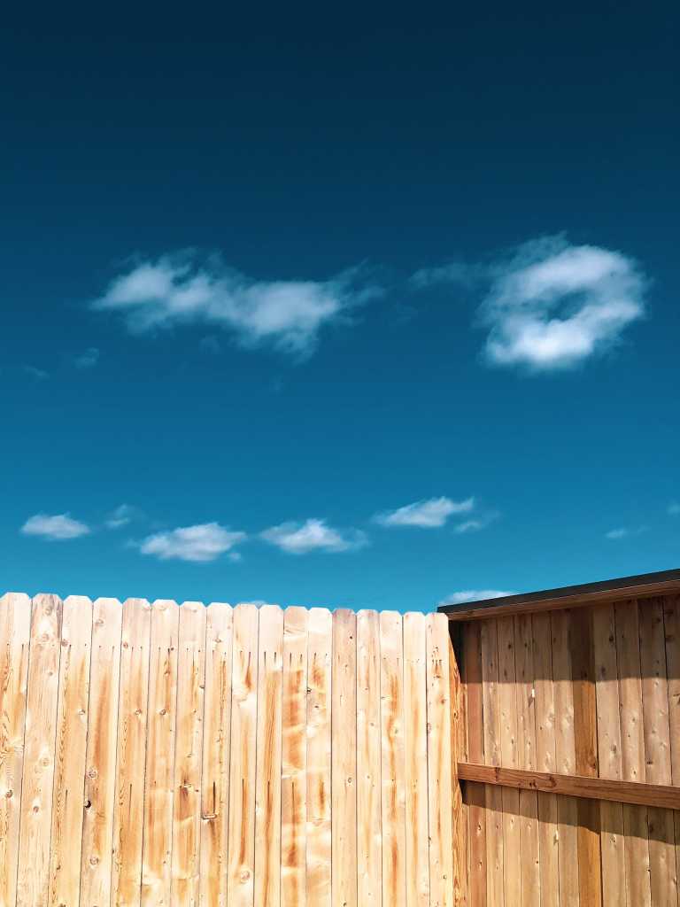 light wood fencing with blue sky above